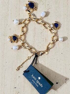 Kate spade bracelet with crab charms,blue stone, white pearl,with a gold chain